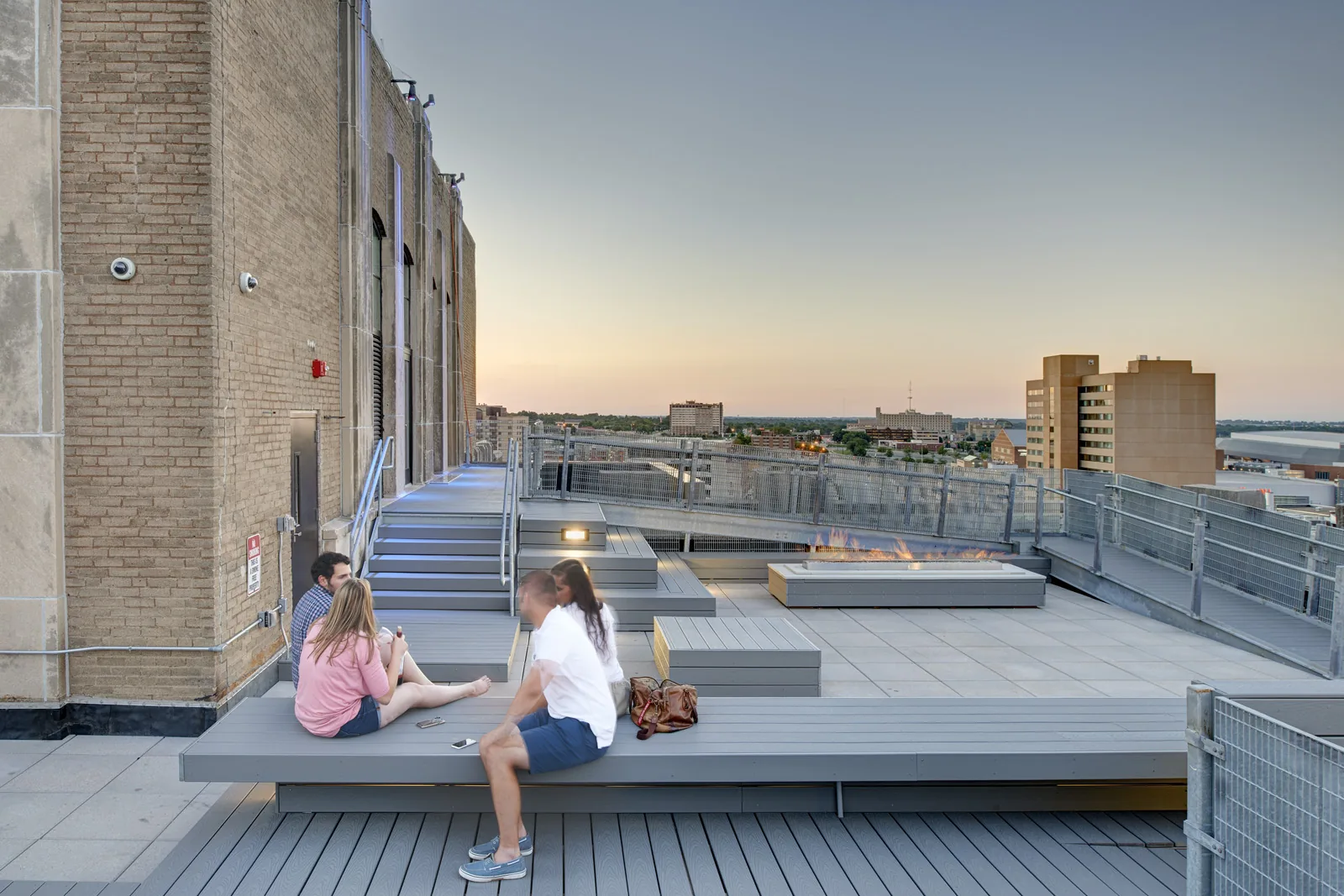 Residents enjoying the building rooftop terrace at dusk