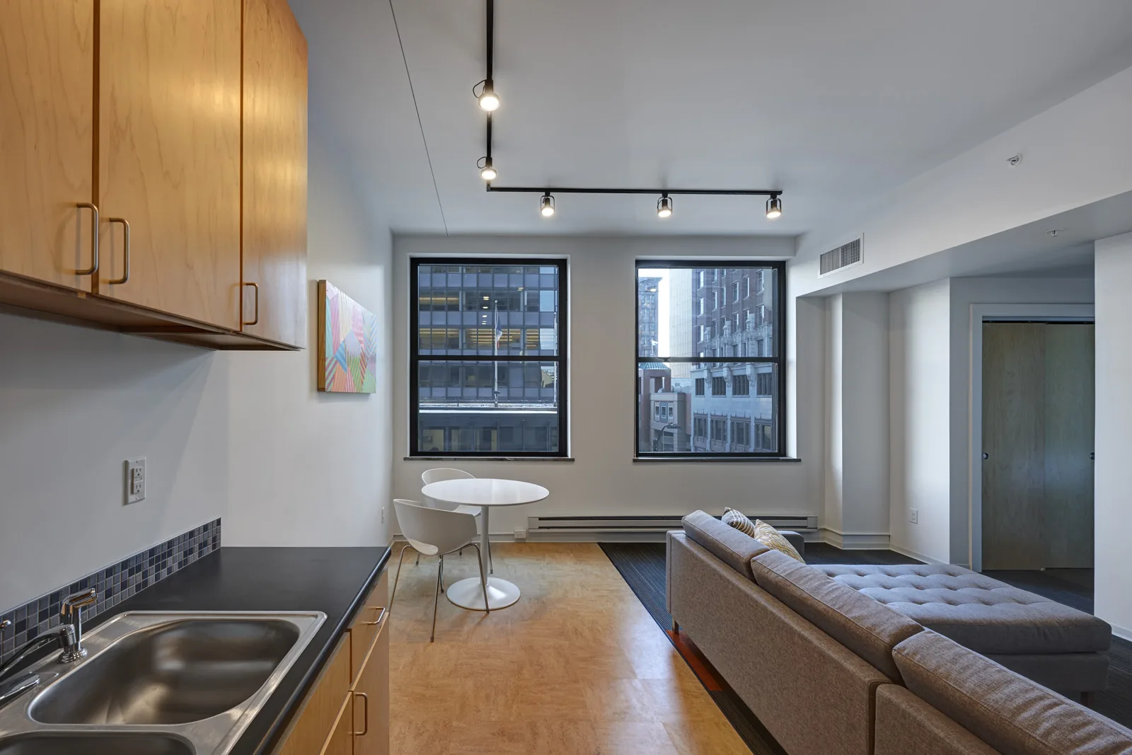 Representative one-bedroom apartment with kitchen island and downtown windows